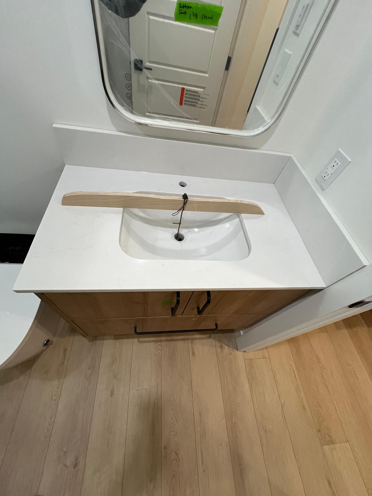 Natural wood vanity cabinet with white quartz countertop and undermount sink