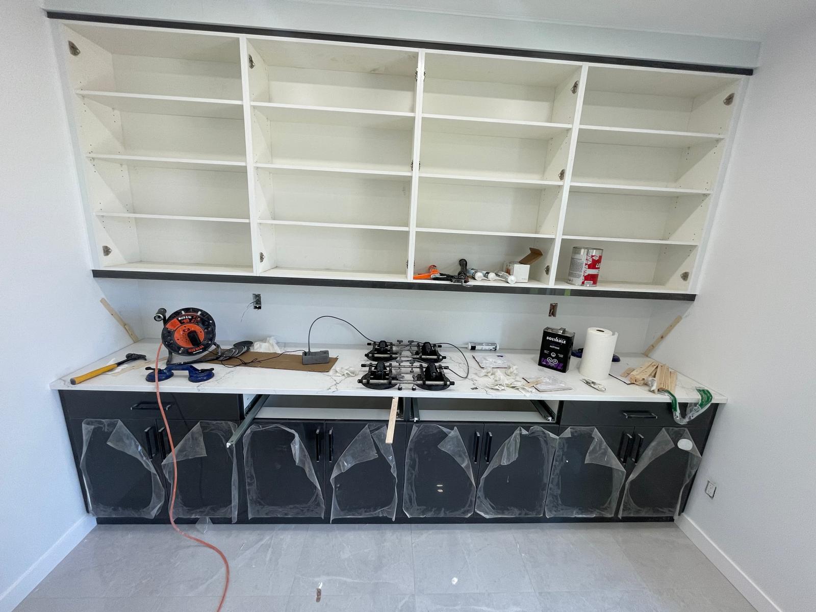 Stone countertop installation in progress with tools and joining clamps