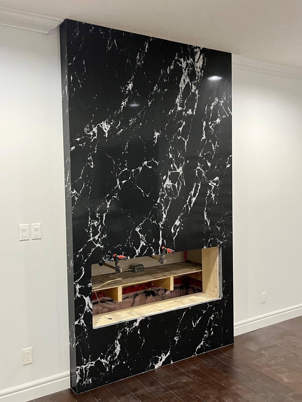 Dramatic black marble fireplace feature wall under construction