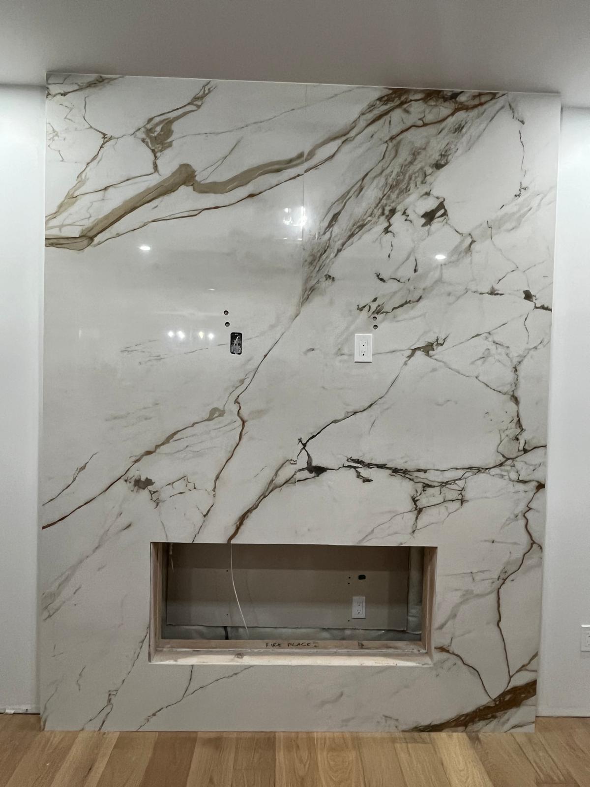 Full-height calacatta marble fireplace wall with open firebox cutout