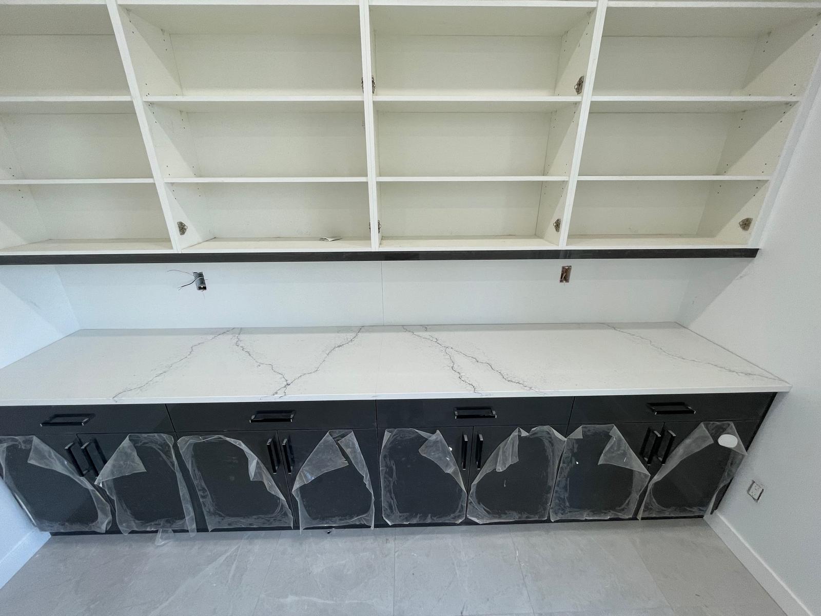 Marble-look quartz countertop on dark built-in unit with open shelving