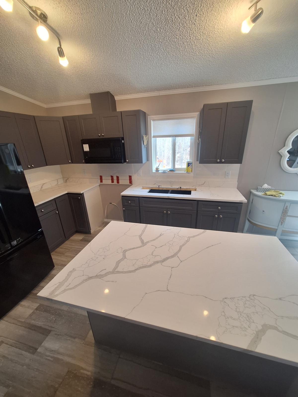 Dark grey kitchen with quartz countertops and large island