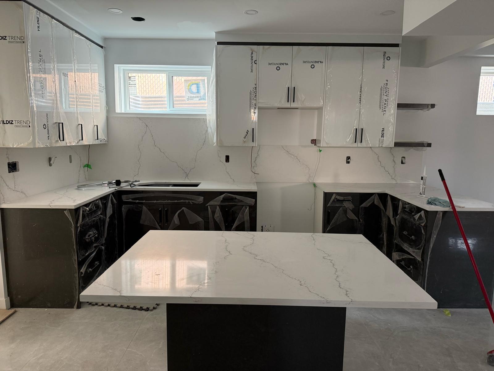 New build kitchen with white quartz countertops and island under construction