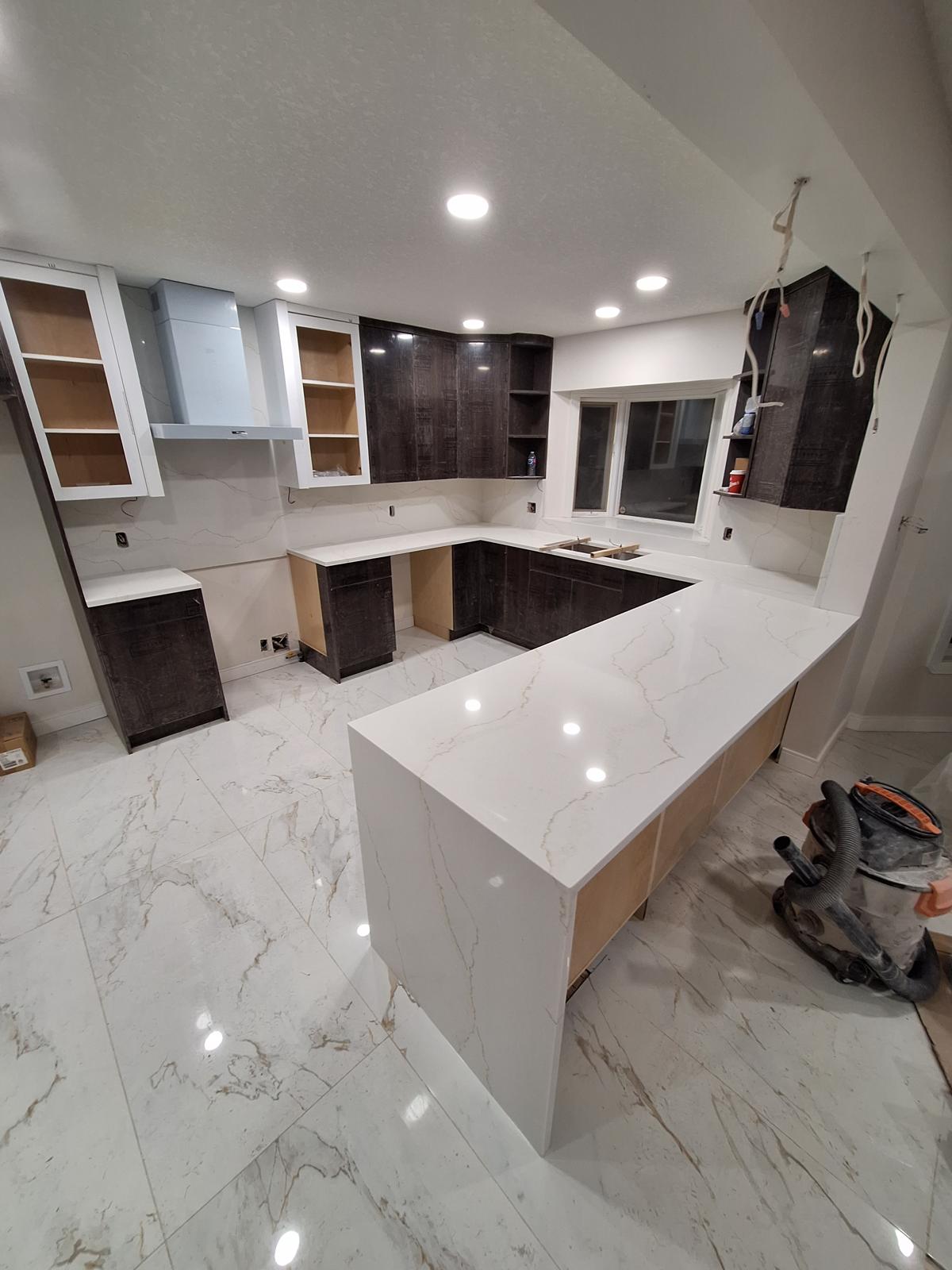 Large kitchen renovation with quartz countertops and dark wood cabinets