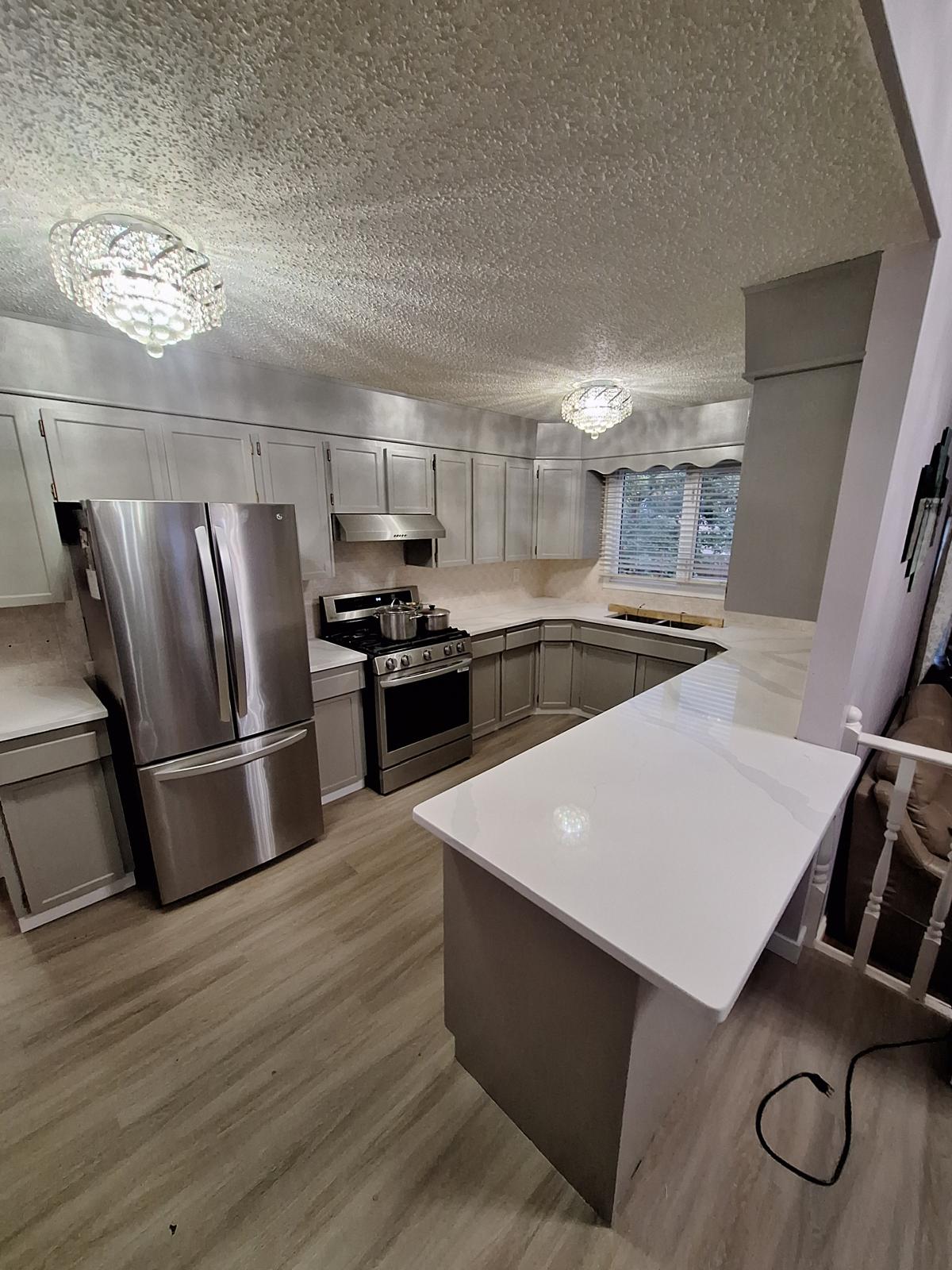 Grey shaker kitchen with white quartz countertops and island