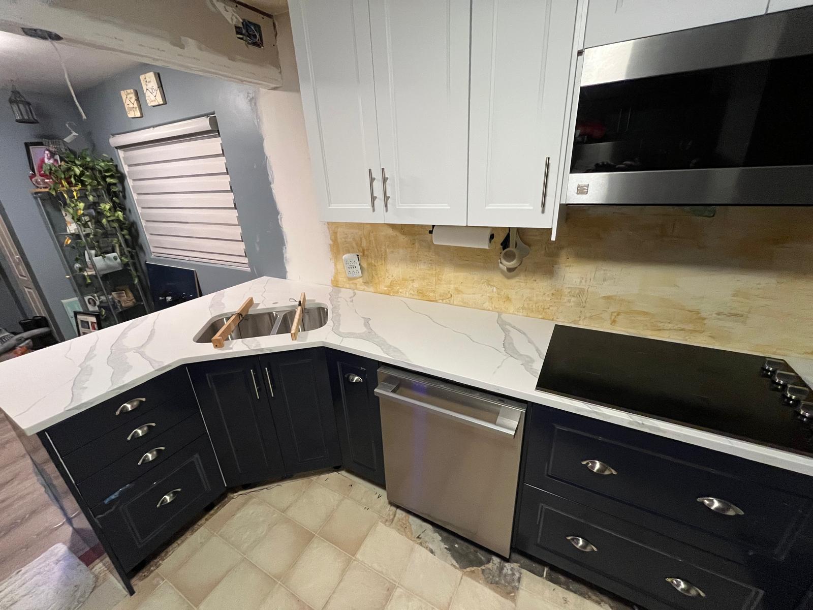 Navy lower and white upper cabinet kitchen with marble-look quartz countertops