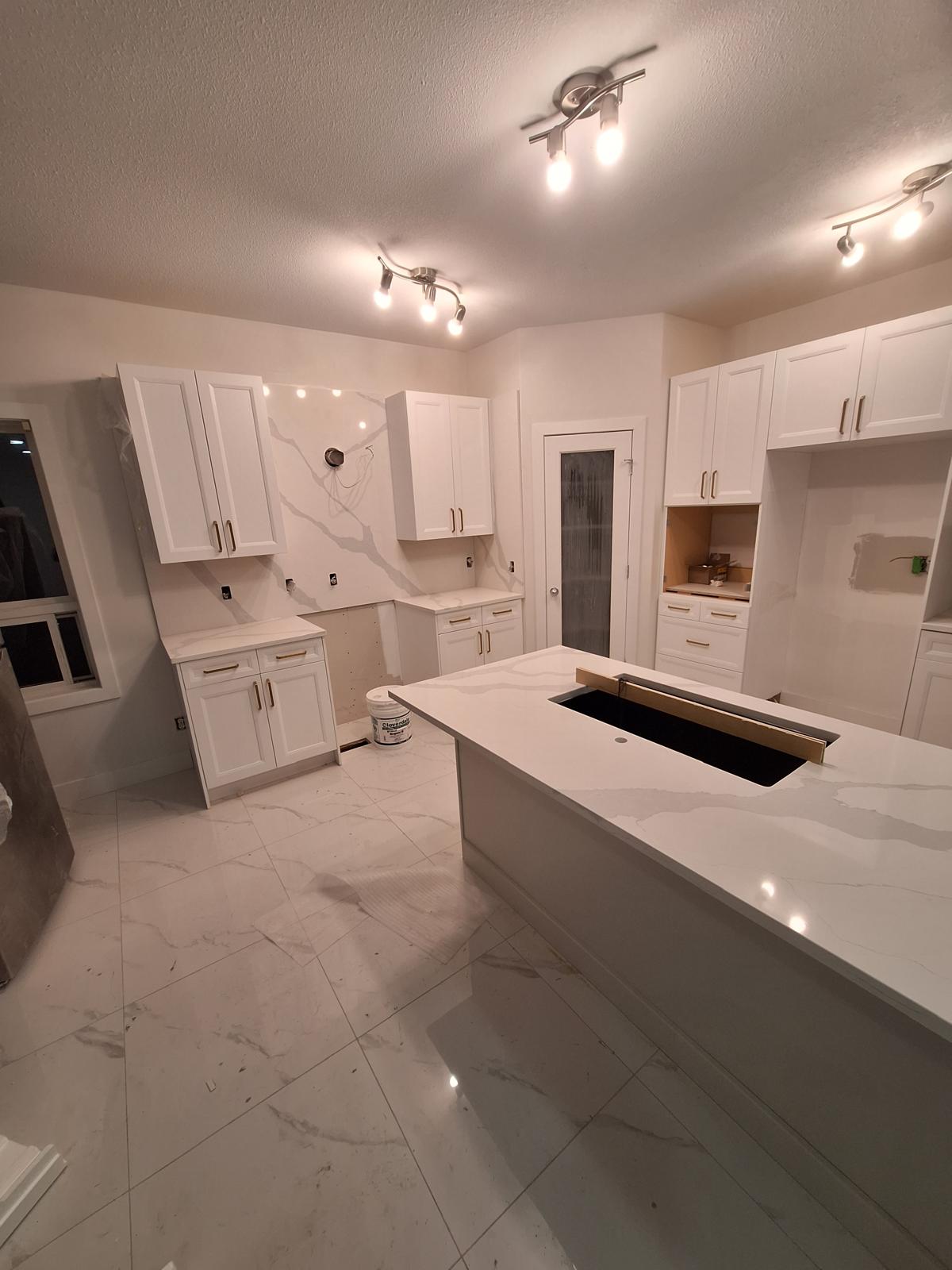 Bright white kitchen with marble-look quartz countertops and waterfall island